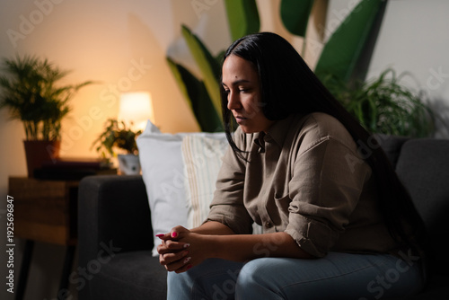Canvas-taulu Woman experiencing sadness and worries alone in living room at night