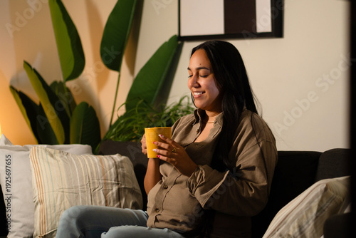 Satisfied woman enjoying warm drink at home