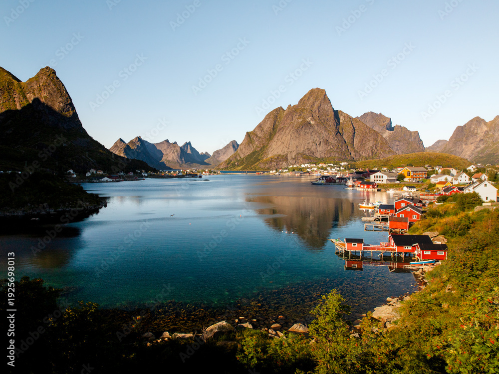 Naklejka premium Inner Harbour of Reine – Iconic Red Fisher Houses on a Sunny Day in Lofoten