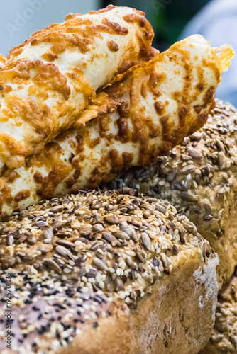 Fresh traditional loaves of wheat or rye bread with grains on stall or in bakery