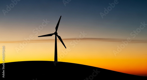 Wind turbine silhouette at sunset on a hill with a colorful sky background renewable energy concept