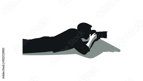 Silhouette of a prone shooter aiming a rifle on a flat surface with negative space