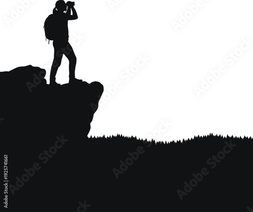 Silhouette of a person standing on a cliff with a camera