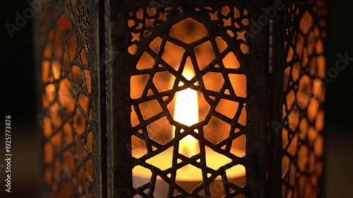 Close-up of a beautiful ornate lantern with a glowing candle inside, creating a warm, ambient light.