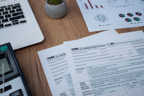 US Individual Income Tax Return Form 1040 with US Dollars and Laptop for Tax Season Concept