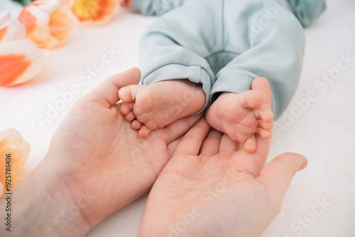 Fotografía Newborn baby feet in caring parent hands