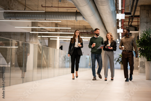 Bild auf Leinwand Business people walking in modern office corridor during coffee break