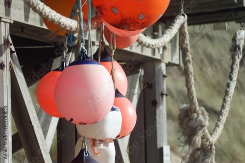Bright red buoys are hanging on a rope from a pier, Sylt, Wenningstedt