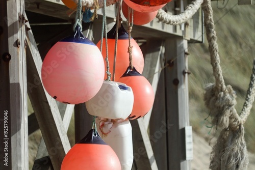 Leuchtend rote Bojen hängen an einem Seil von einem Steg runter, Sylt, Wenningstedt