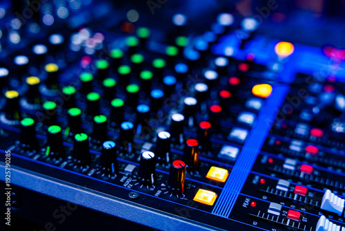 Professional Audio Mixing Console with Colorful Control Knobs in Blue Neon Lighting
