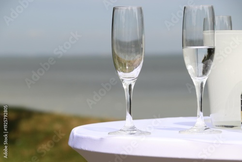 Glasses and sparkling wine on a white standing table on the beach create a festive atmosphere, Sylt, Keitum