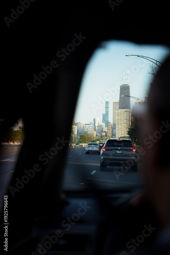 Wallpaper Mural View of a Car Driving Down a Chicago Street at Sunrise with Tall Buildings Surrounding it Torontodigital.ca