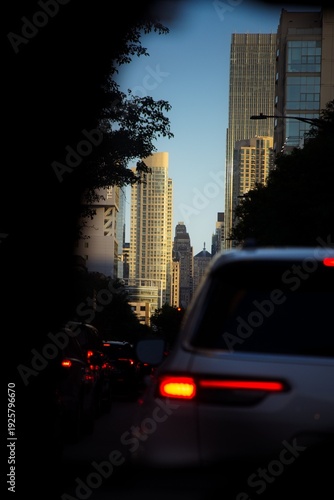 Wallpaper Mural View of a Car Driving Down a Chicago Street at Sunrise with Tall Buildings Surrounding it Torontodigital.ca