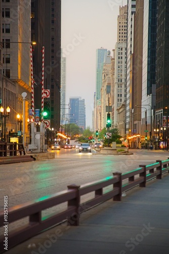 Wallpaper Mural View of a Car Driving Down a Chicago Street at Sunrise with Tall Buildings Surrounding it Torontodigital.ca