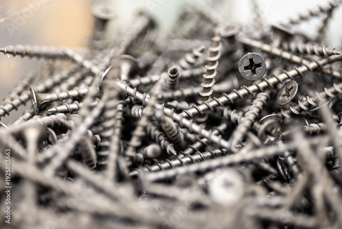 Pile of metal screws and bolts for construction and woodworking industry professional hardware