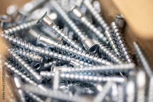 Pile of metal screws and bolts for construction and woodworking industry professional hardware