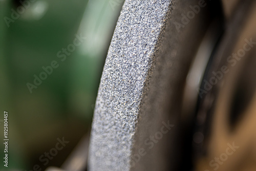 Bench grinder machine with abrasive stone wheel for sharpening tools in industrial workshop