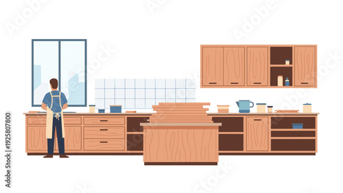 Carpenter working in a modern kitchen with wooden cabinets and tools