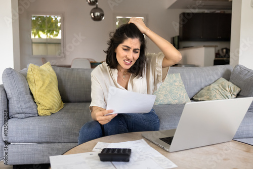 Cuadro en lienzo Frustrated worried young Latin woman counting too high expenses, reviewing bill,