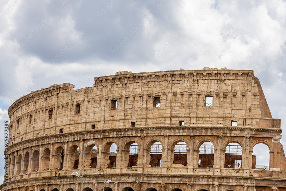 Obraz premium Famous tourist attraction of historic Colosseum amphitheatre with ancient stone arches in Rome Italy