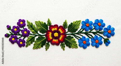 Vibrant floral embroidery design showcasing colorful hand-stitched flowers and lush green leaves on a pristine white fabric.