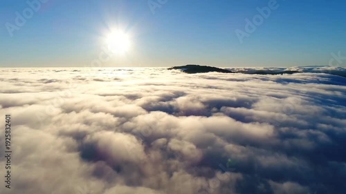 Aerial View Above Clouds with Bright Sun in Blue Sky