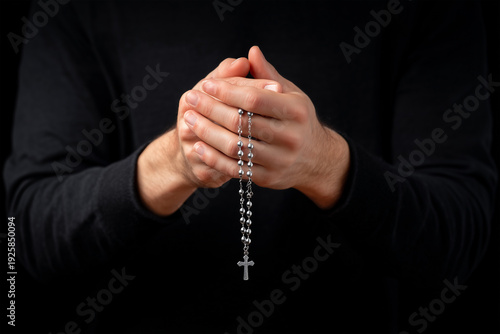 Holding a silver rosary with gentle faith in quiet reflection