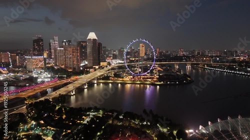 Singapore by Night – 4K aerial drone footage of marina bay sands, city skyline, skyscrapers, luxury hotels, and river illuminated in financial district (CBD).