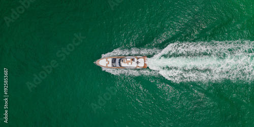 Top aerial view on motorboat. Motor boat yacht floating to marina. Motorboat tour by summer sea. Luxury yacht boat at sea. Summer vacation. Luxury yacht boat top view. Blue ocean.