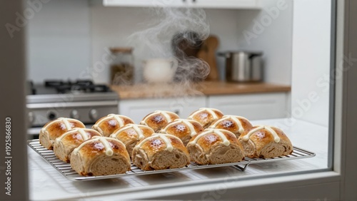 View through slightly steamy kitchen window of golden-brown hot cross buns cooling on a wire rack, framed by bright Australian flora.