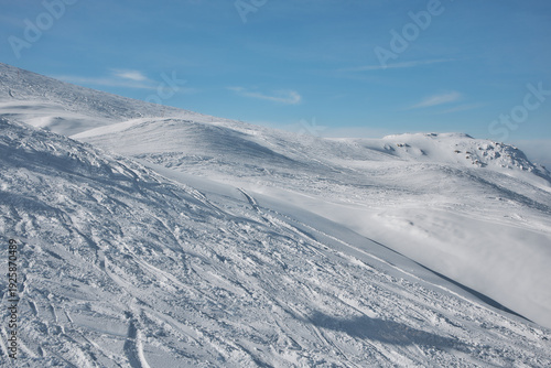 Wide snowy alpine ridge under blue sky, Stoos Switzerland