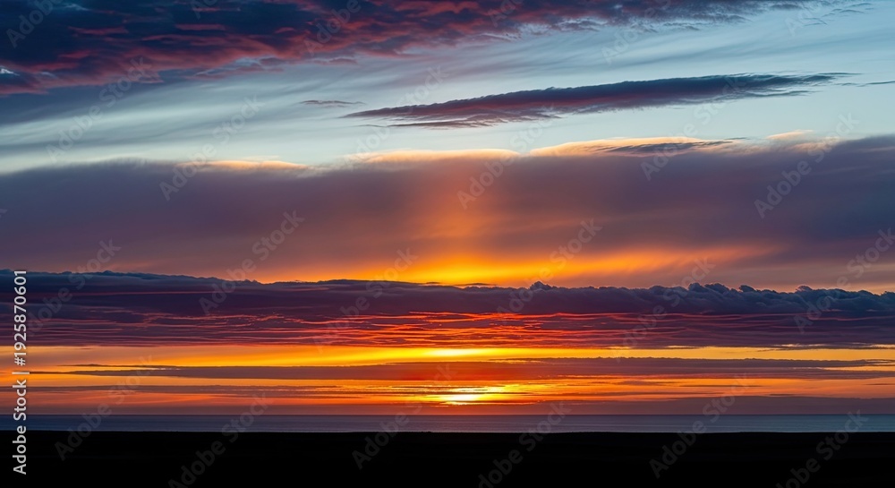 Fototapeta premium Dramatic Sunset Sky with Vibrant Colors and Crepuscular Rays over Horizon