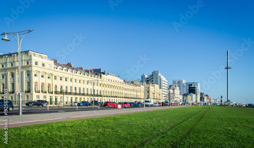 Fotografie Street view of Brighton beach front buildings in a sunny day with green grass and blue sky