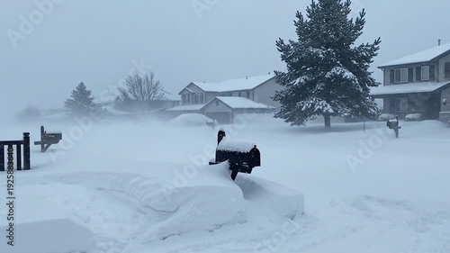 Snowy residential street with mailboxes covered in snow during blizzard