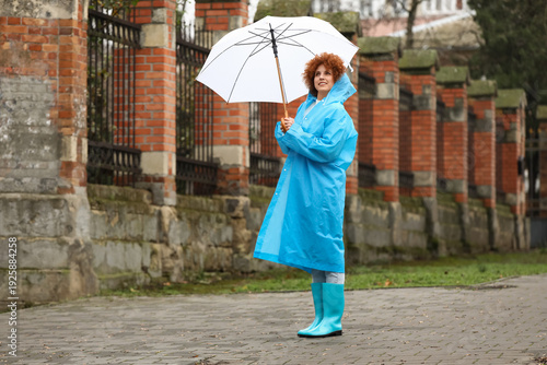 Foto Young woman in blue raincoat with umbrella outdoors