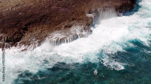 Impresionante vista aérea de las olas rompiendo sobre las rocas rojizas de Aruba