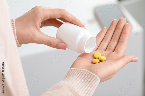 Young woman taking vitamin ...