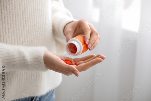 Young woman taking vitamin ...