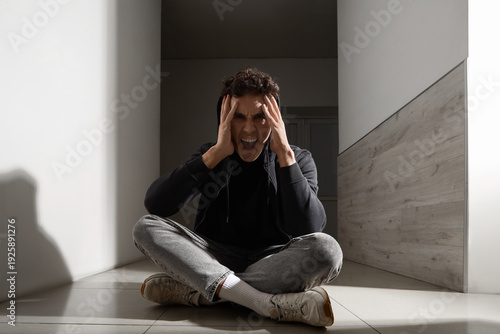 Screaming young man sitting...