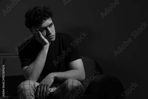 Upset young man sitting on ...