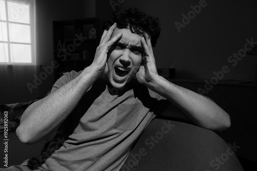 Screaming young man sitting...
