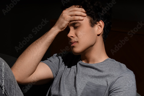 Sad young man sitting on so...