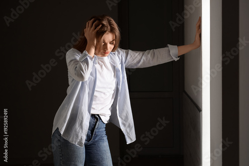 Depressed young woman in da...