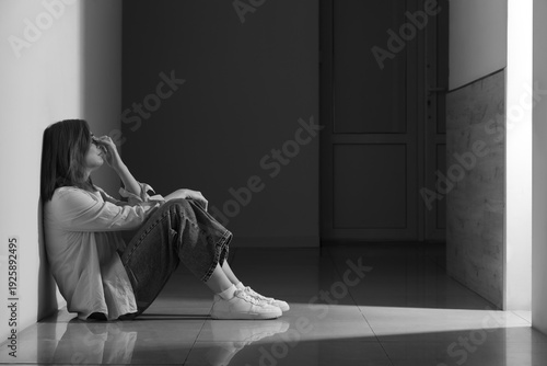 Sad young woman sitting on ...