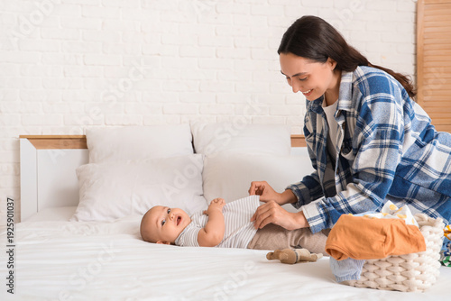 Mother dressing her little ...