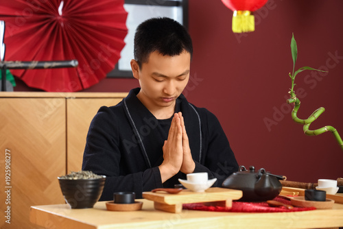 Young Asian man with tea se...