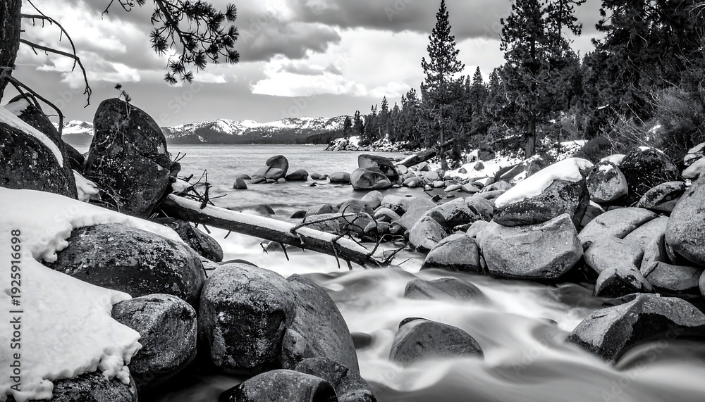 Fototapeta premium A serene winter landscape with a stream flowing through rocks and trees