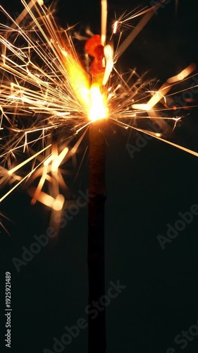 4K Vertical Close up of sparkler burning with bright sparks and glowing light trails in the dark Celebration, Concept featuring festive energy holiday atmosphere and abstract fire texture.