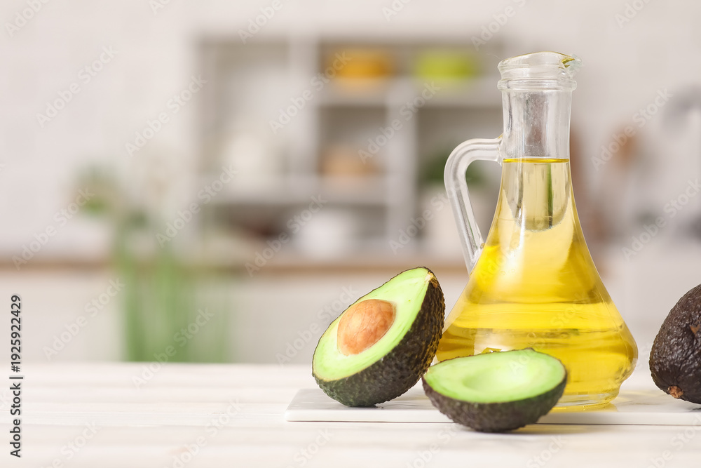 Obraz premium Jug of fresh avocado oil on white wooden table in kitchen