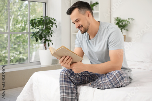 Handsome man reading book i...